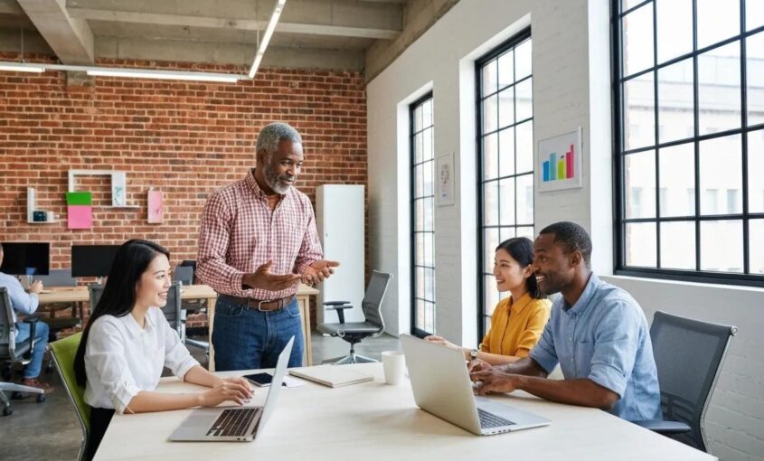 A diverse team of entrepreneurs collaborating on a digital marketing strategy in a modern office setting